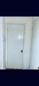 - une porte blanche dans une chambre blanche avec une porte dans l'établissement Service Apartment, à Thamesmead