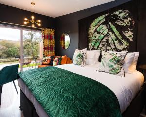 a bedroom with a large bed with a green blanket at The Old Manse of Blair, Boutique Hotel & Restaurant in Blair Atholl