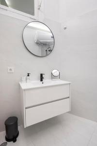 a white bathroom with a sink and a mirror at Petit studio Rosa - Bairro Alto in Lisbon