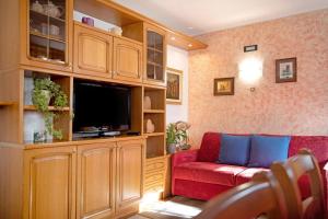 a living room with a red couch and a flat screen tv at Chalet Maffins 1 in Livigno