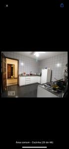 a kitchen with a stove and a white refrigerator at Alto Bueno Ofurô Hospital Premium Jaime Câmara Mercatto Store Moreira Marista Blue Fit Perdomo Vaca Brava Goiânia Shopping Areião Marista Ze Abílio Serrinha Campo do Goiás Maná in Goiânia