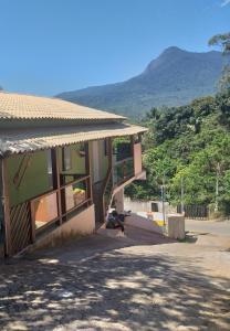 a building with a staircase and a mountain in the background at Casa do Mar & Ane Ilhabela in Ilhabela