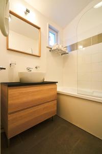 a bathroom with a sink and a mirror and a tub at Les Cottages Du Lac in Parentis-en-Born