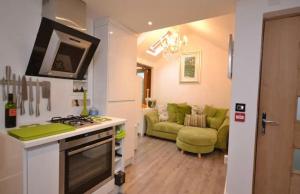 a kitchen and living room with a stove and a couch at Compact, central apartment, dog friendly. in Kingsbridge