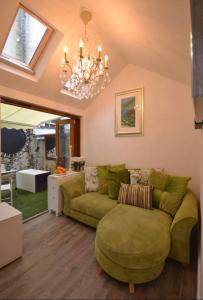 ein Wohnzimmer mit einem grünen Sofa und einem Kronleuchter in der Unterkunft Compact, central apartment, dog friendly. in Kingsbridge