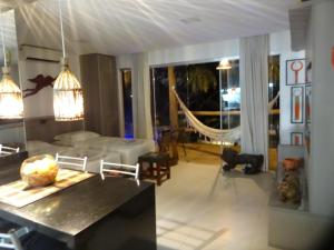 a living room with a couch and a table at Bangalô no alto da colina no Villas do Pratagy - Maceió in Maceió +37 photos