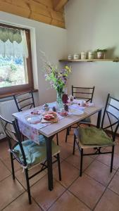 een eettafel met een vaas met bloemen erop bij APARTHOTEL STREMBO in Strembo
