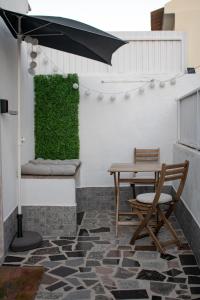 a patio with a table and a green wall at Stone House - Sintra Rural in Sintra