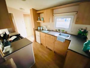 una pequeña cocina con fregadero y ventana en 707 Seawick, en Jaywick Sands