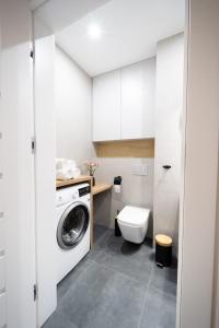 a small bathroom with a washing machine and a toilet at Apartament pod Szyndzielnią in Bielsko-Biała