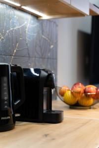 a coffee maker on a counter next to a bowl of fruit at Apartament pod Szyndzielnią in Bielsko-Biała