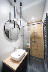 y baño con lavabo, ducha y espejo. en Apartament pod Szyndzielnią, en Bielsko-Biala