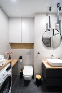 ein Badezimmer mit einer Waschmaschine und einem Waschbecken in der Unterkunft Apartament pod Szyndzielnią in Bielsko-Biała