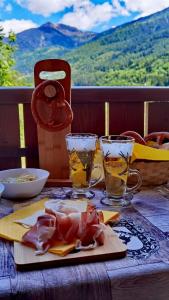 een tafel met een bord eten en twee glazen bij APARTHOTEL STREMBO in Strembo