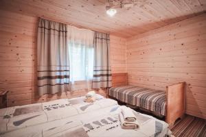 a bedroom with two beds in a log cabin at Старий Млин in Beloberëzka