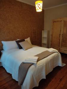 - une chambre avec un grand lit blanc et des serviettes dans l'établissement Appartamento in centro Tollegno, à Tollegno