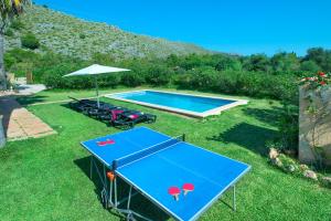 una mesa de ping pong azul con sillas y sombrilla en Owl Booking Villa Punta Magdalena - Family Holidays, en Pollensa