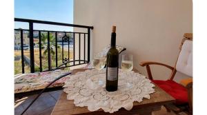 a bottle of wine sitting on a table with two glasses at Petras Cozy Nest, 1-bedroom apt., Paphos-Universal in Paphos