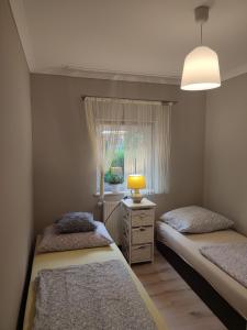 two beds in a small room with a window at Domki Na Źródlanej in Międzybrodzie Bialskie