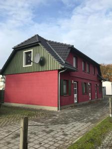 een rood gebouw met een zwart dak bij Ferienwohnung Seestraße 67 in Zingst +9 foto's