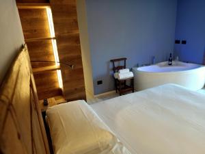 a bedroom with a bed and a tub and a sink at Maison Bionaz Ski & Sport in Aosta