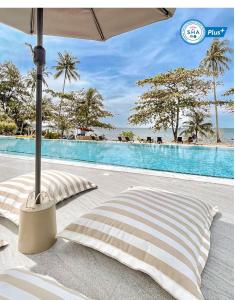 uma piscina com duas almofadas e um guarda-chuva ao lado em Shantaa Resort, Kohkood em Ko Kood