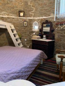 a bedroom with a bed and a vanity and a mirror at The Windmill in Symi