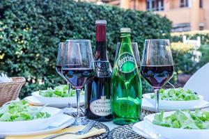un tavolo con tre bottiglie di vino e piatti di cibo di Artemisia B1 Apartment by Wonderful Italy a Sirmione