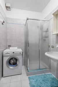 una lavatrice in un bagno con doccia di Artemisia B1 Apartment by Wonderful Italy a Sirmione