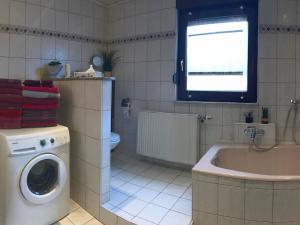 a bathroom with a washing machine and a sink at Ferienwohnung Elisabeth in Burgbernheim