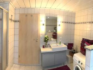 y baño con ducha, lavabo y espejo. en Ferienwohnung Elisabeth, en Burgbernheim