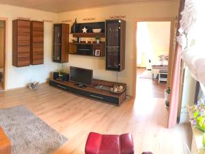 a living room with a television and a wooden floor at Ferienwohnung Elisabeth in Burgbernheim