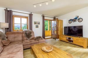 a living room with a couch and a flat screen tv at Ferienhaus Thimlefi in Reit im Winkl