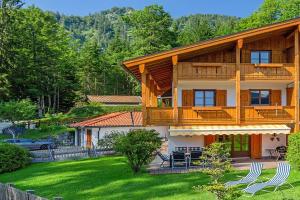 a large wooden house with a porch and a yard at Ferienhaus Thimlefi in Reit im Winkl