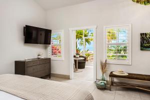 a bedroom with a bed and a tv and windows at Islander Resort in Islamorada