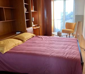 um quarto com uma cama grande e uma cadeira em Appartement vue mer à 100m de la plage au centre de Carantec em Carantec