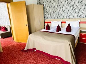 una habitación de hotel con una cama grande con alfombra roja en Vile Verdi en Baile Felix