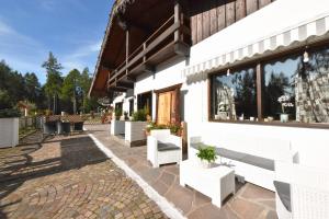 a patio with white benches and a building at Lo Chalet delle Ville in Varena
