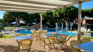 patio ze stołami i krzesłami przy basenie w obiekcie Bicos S by Check-in Portugal w Albufeirze