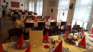 a dining room with tables with red napkins on them at Vorsfelder Hof in Wolfsburg