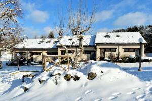 a house covered in snow with a fence in front at Val Du Rio in Le Chambon-sur-Lignon