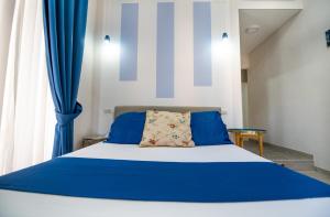 Un dormitorio con una cama azul y blanca con cortinas azules en La Chambre, en Nápoles
