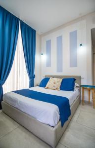 a bedroom with a large bed with blue curtains at La Chambre in Naples
