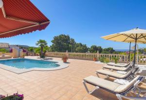 een patio met stoelen, een zwembad en een parasol bij Casa Siempre Domingo in Moraira