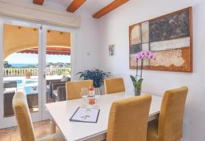 een eetkamer met een witte tafel en stoelen bij Casa Siempre Domingo in Moraira
