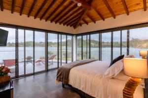 a bedroom with a bed and large windows at Jordan Hotel Boutique in Guatapé