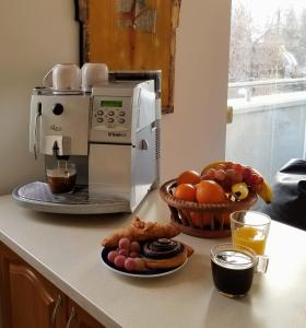 a counter with a coffee maker and a bowl of fruit at New Pest Apartman in Budapest