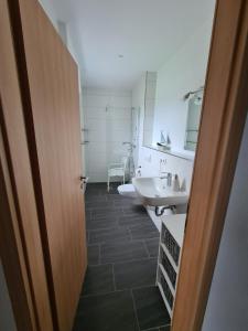 a bathroom with a sink and a toilet and a tub at Ferienwohnung Hennemann in Schmallenberg +24 photos