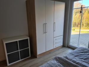 a bedroom with white cabinets and a bed and a window at Ferienwohnung Hennemann in Schmallenberg