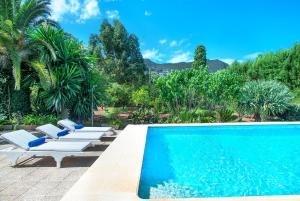 a swimming pool with two lounge chairs next to it at Owl Booking Villa La Font - Relax with a Big Pool in Pollença